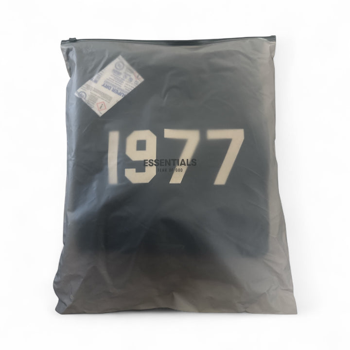 Fear of God Essentials hoodie packaged in a clear bag, featuring the year '1977' and the Essentials logo.