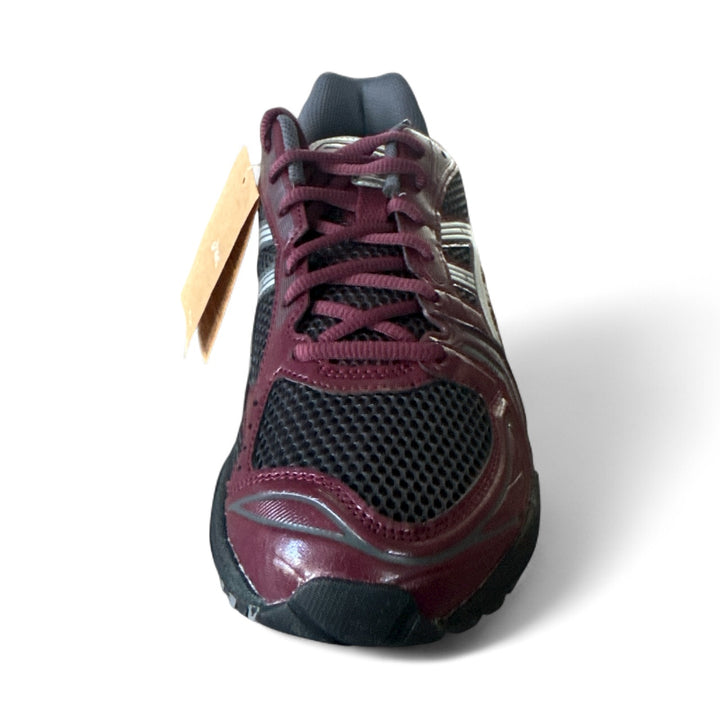 ASICS Gel-Kayano 14 running shoes in burgundy color, showcasing the front view with laces and tag.