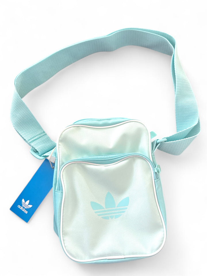 adidas festival crossbody bag in light blue with durable materials and adjustable strap.