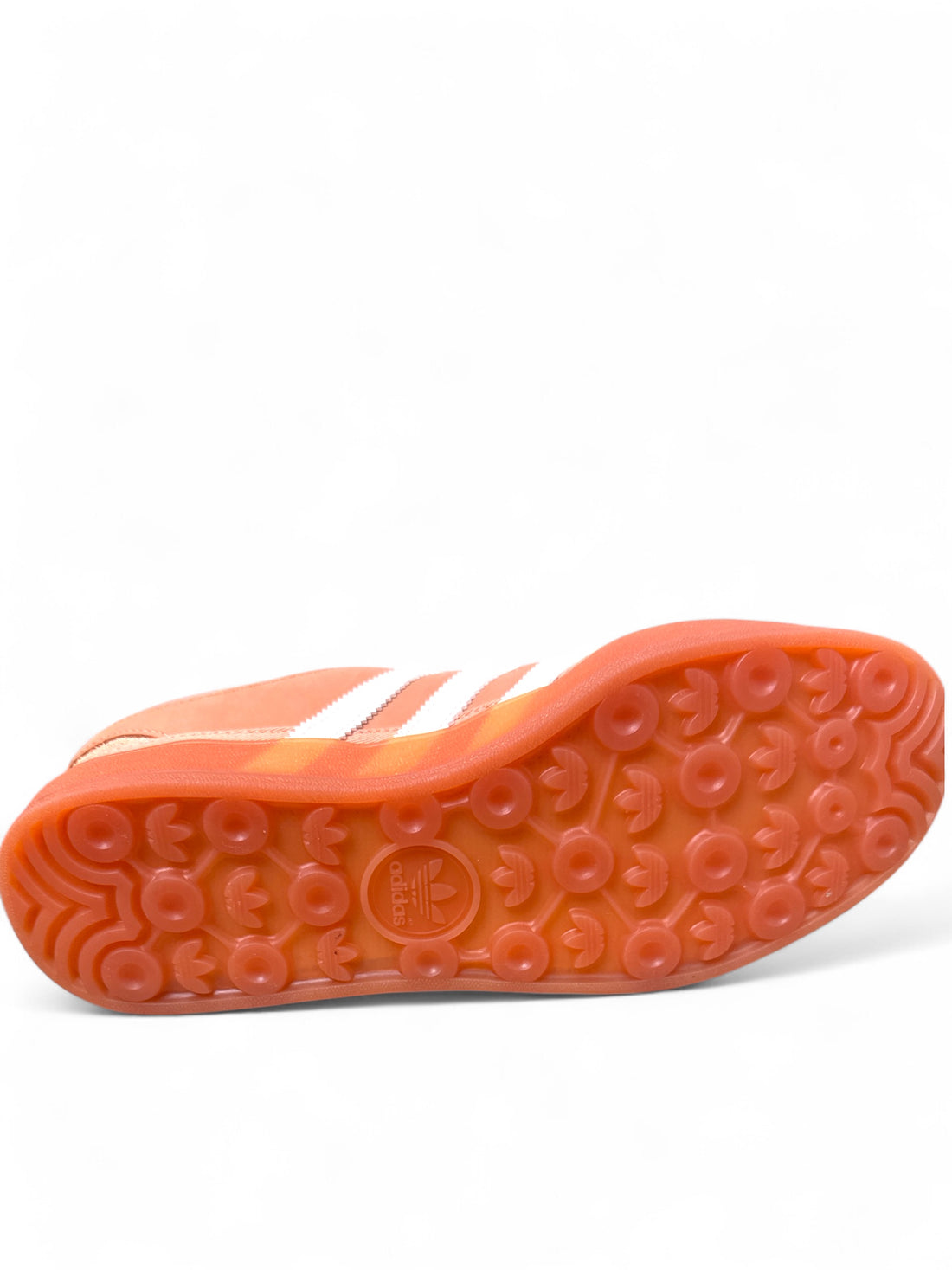 adidas Gazelle Bad Bunny sneakers sole view showcasing vibrant orange color and signature three stripes design.