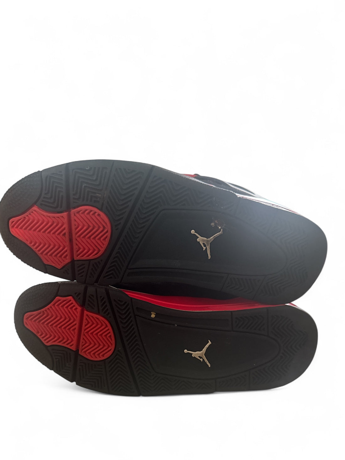 pre-owned Jordan 4 Retro Red Thunder sneaker sole view showcasing red and black design.