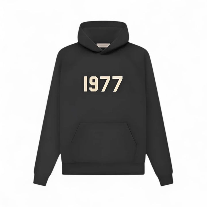 Fear of God Essentials hoodie in black with 1977 logo, combining comfort and streetwear style.